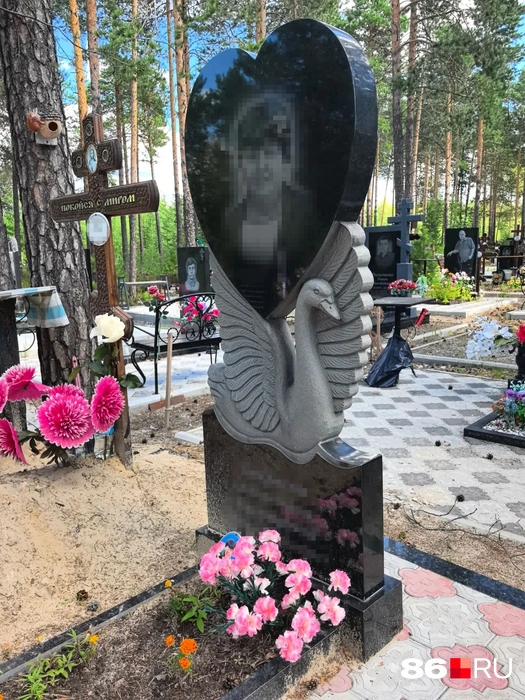 Очень красивый памятник Чернореченского кладбища Сургута — белый лебедь держит на плечах мраморное сердце с изображением усопшей югорчанки | Источник: Анастасия Шевякова / 86.RU