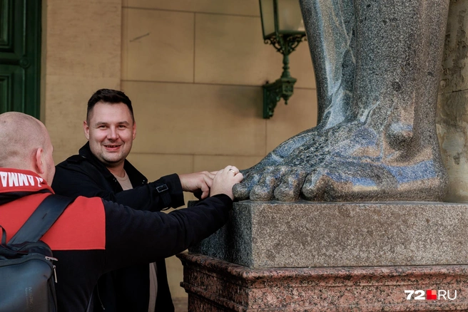 Одна из туристических традиций — потереть пальцы атлантов | Источник: Ирина Шарова / 72.RU
