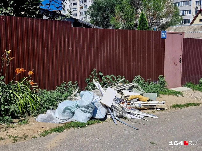 Люди своими силами тоже собирают строительный мусор, разлетевшийся по округе | Источник: Виктория Федорова / 164.RU