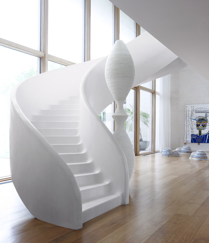 Белая скульптура у лестницы сделана из двух ваз и обмотана канатом. На заднем плане, на стене, — работа Жан-Мишеля Баскиа.