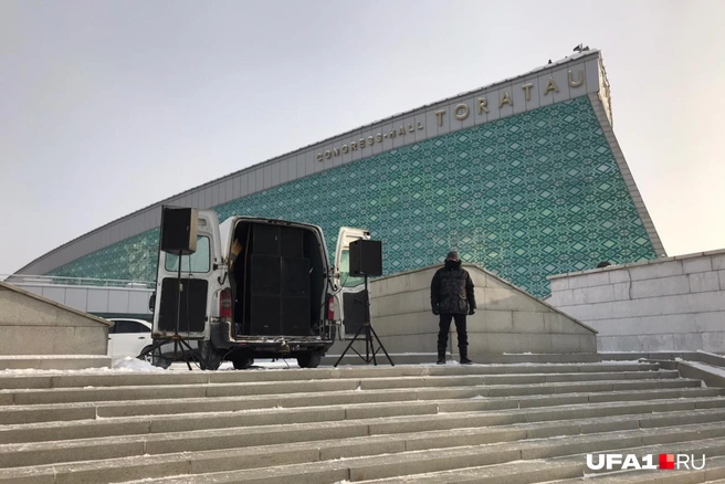 Этот человек отвечал за музыку на митинге — все это время он неподвижно стоял у машины с колонками