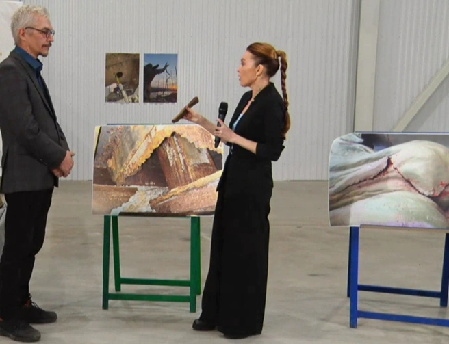 Ведущая держит в руках ржавый фрагмент конструкции памятника | Источник: БСТ