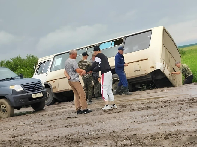 Рядом с перевернувшимся автобусом стоят люди | Источник: «Новосибирск с огоньком» / Telegram