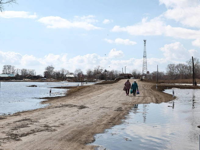 Некоторые жители, несмотря на паводок, всё же добираются до магазина. | Источник: Александр Ощепков / NGS.RU