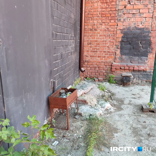 За ее стенами чернённый пристрой, у одной двери стоит запыленный принтер, а с другой — мангал | Источник: Ксения Власова / «ИрСити»
