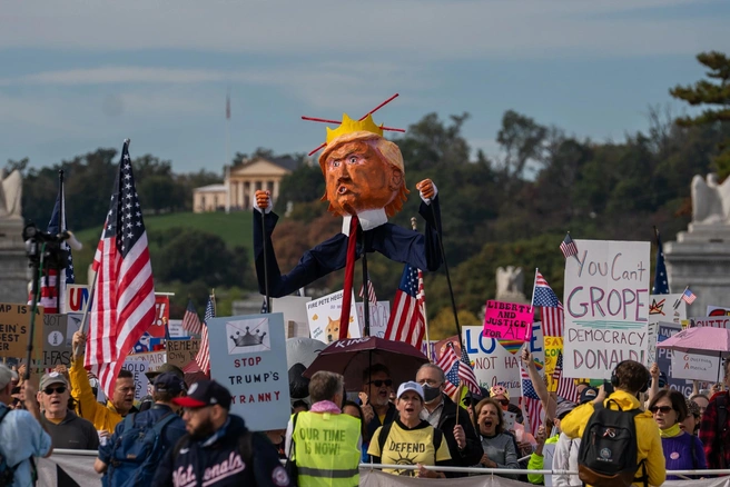 Люди выходят на улицы с транспарантами, флагами и одеваются в яркие костюмы | Источник: Allison Robbert / Assotiated Press