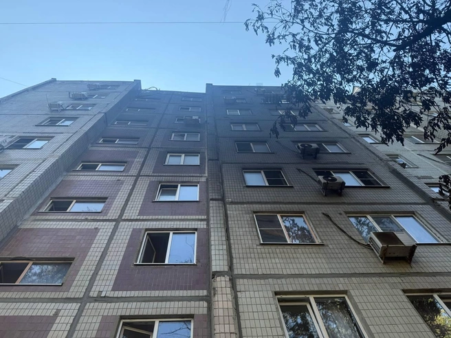 Обгоревший фасад девятиэтажки. Жильцы открыли окна, в квартирах очень сильно пахнет гарью, так что люди вышли во двор | Источник: Марина Рыбалкина / 161.RU