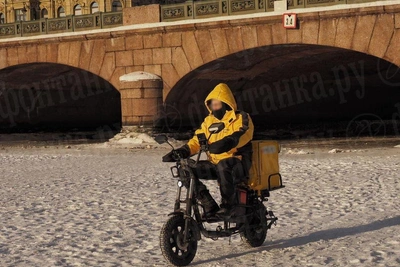 Courier rides across frozen Fontanka under Anichkov Bridge