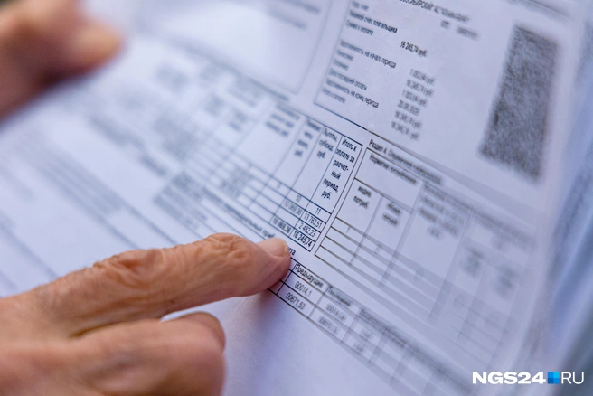 Женщина показывает платежку | Источник: Мария Ленц / NGS24.RU