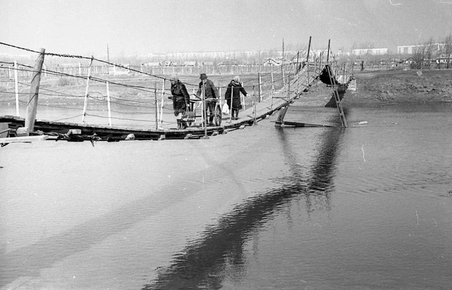 1974 год. Жители поселка Мелькомбинат переходят реку Миасс по подвесному мосту | Источник: С. Егурный, фонды ОГАЧО