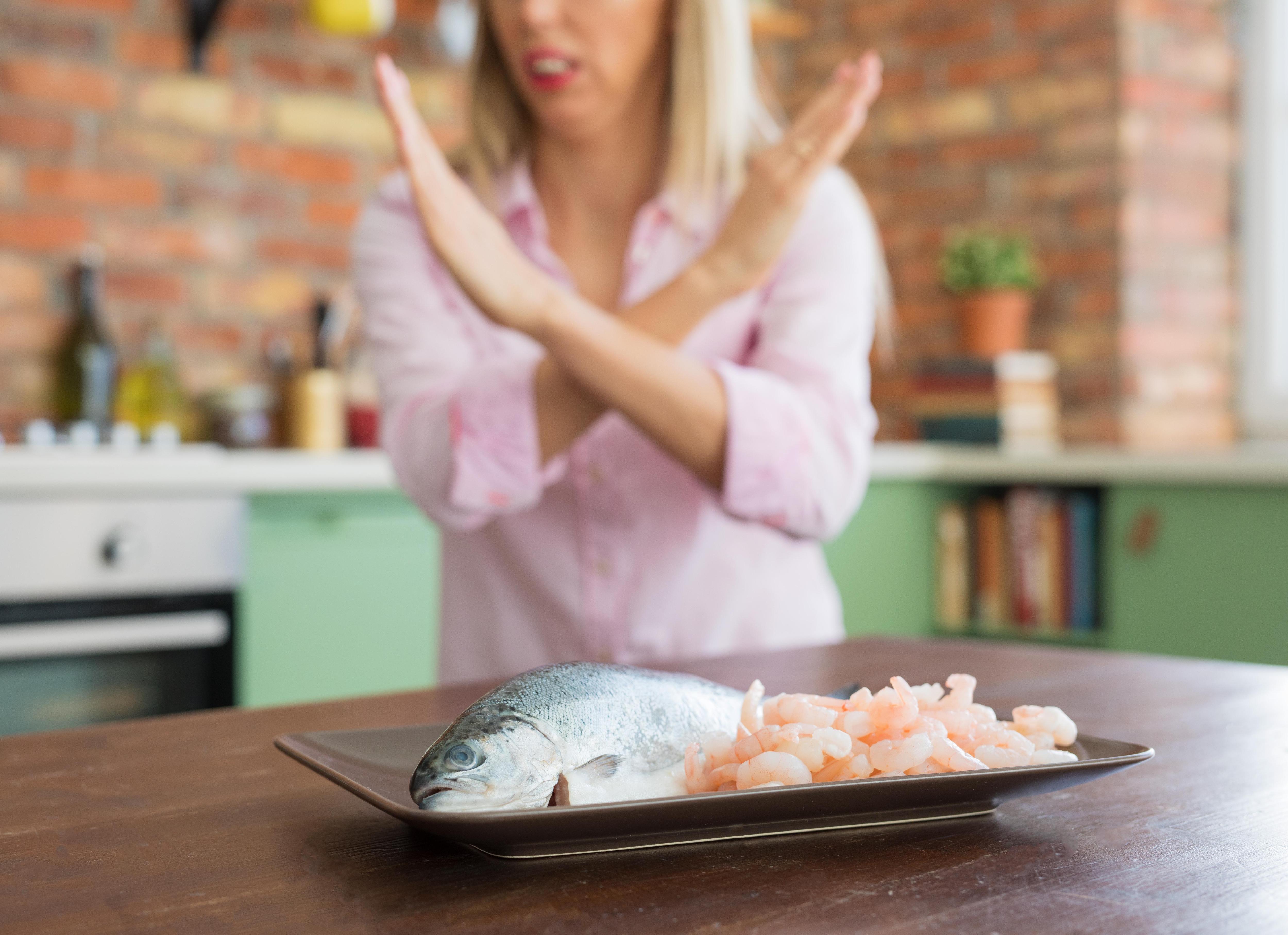Может быть аллергия на рыбу. Морепродукты аллергены. Аллергия на морепродукты. Женщина ест рыбу.