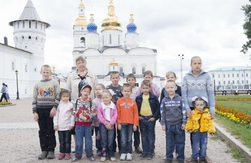 Всем дочерям и сыновьям Лена становится крестной мамой.  На фото с 14 приемными детьми: первый ряд, слева направо: Семен (11 лет), Александра (6 лет), Иван (6 лет), Вильдана (6 лет), Вика (5 лет), Леня (9 лет), Тимур (8 лет), Владик (6 лет),  Света(5 лет). Вверху: Елена Марат(10 лет), Андрей(9 лет), Вера(9 лет), Ксения(12 лет), Лена(12 лет) | Источник: Олег Еперин