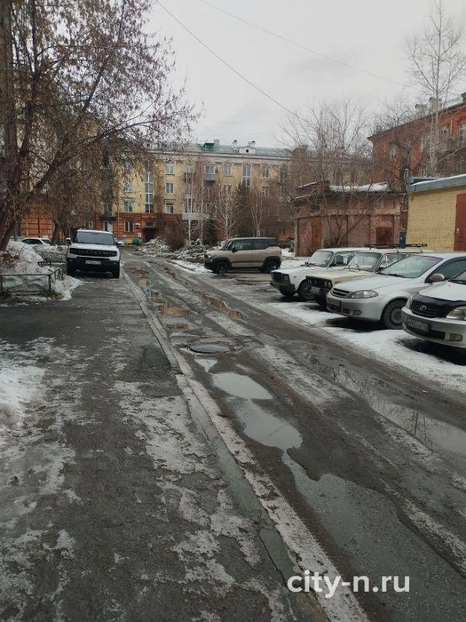 Общий вид дворовой территории. Видна припаркованная на тротуаре машина и свободные места на асфальтированной стоянке. | Источник: www.city-n.ru
