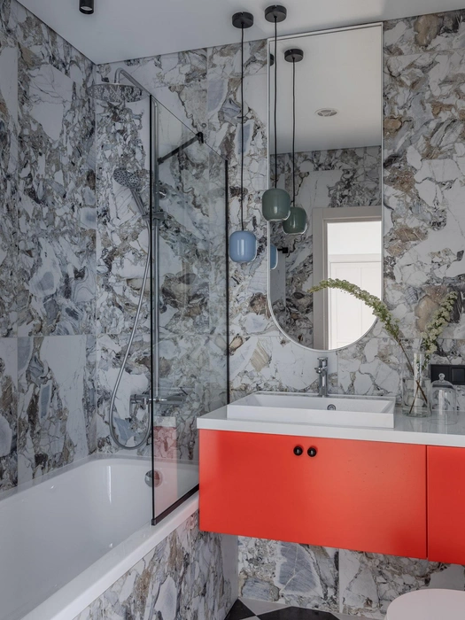 Ванная комната получилась разноцветной. Голубые шкафы, ярко-красная тумба и подвесы перекликаются с оттенками керамогранита под мрамор | Источник: Роман Спиридонов / myDecor