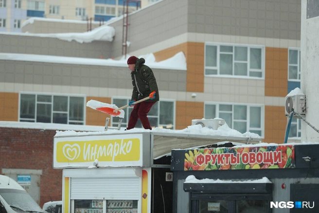 Владельцы соседних киосков спешно чистят крыши | Источник: Андрей Бортко / NGS.RU