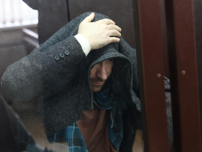 На судебном заседании обвиняемый скрывал лицо от камер. | Источник: Владислав Лоншаков / E1.RU