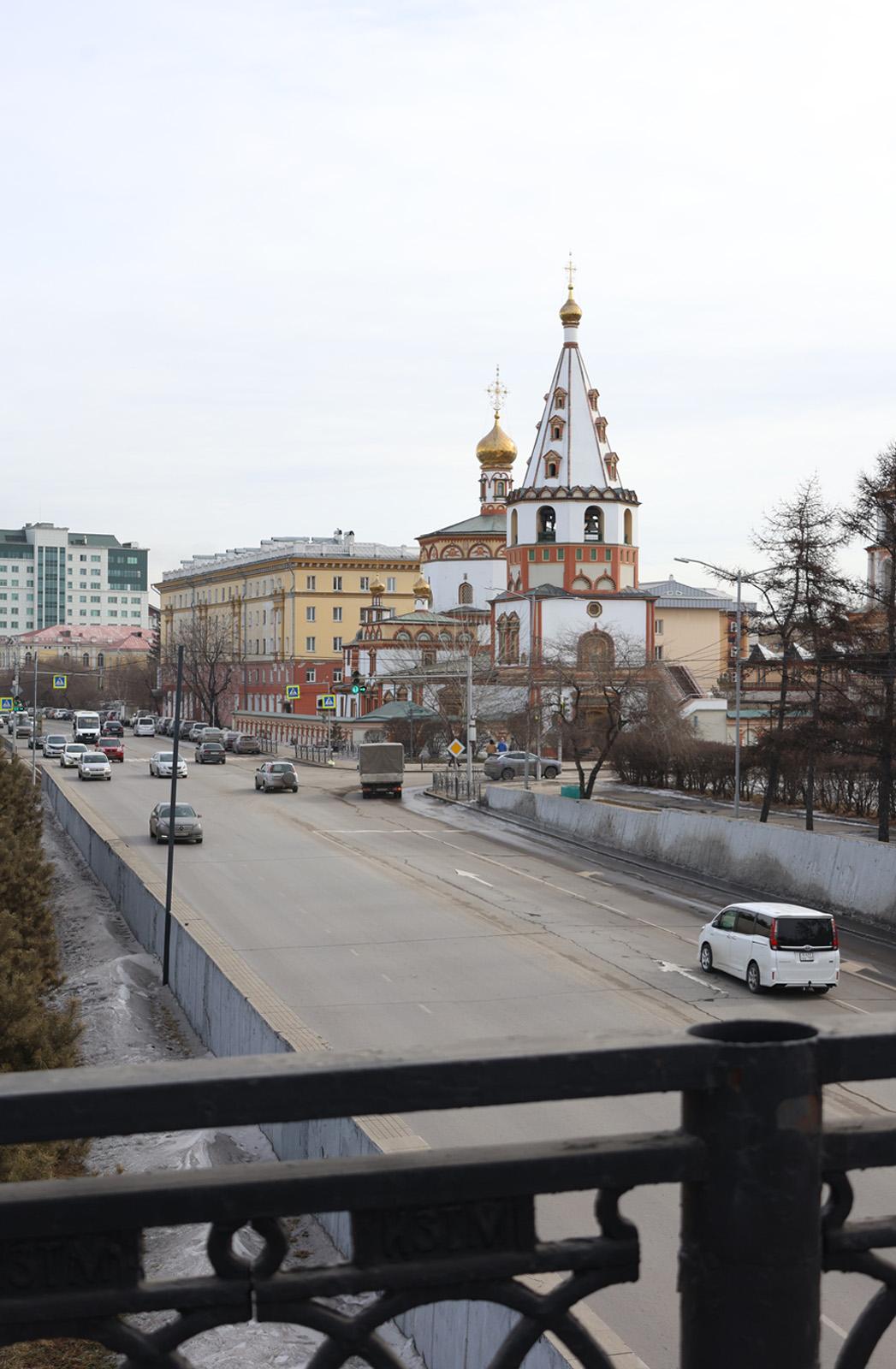 Вид на улицу Нижняя Набережная с мостика, ведущего к реке от Вечного огня. Старое фото снято примерно в середине 1970-х. Тогда религиозные сооружения находились в плачевном состоянии. Вот и Богоявленский собор выглядит печально без своего удивительного фасада. Зато, кажется, 50 лет назад дорога здесь была намного лучше | Источник: Ксения Филимонова, IRCITY.RU