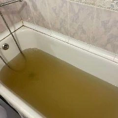Изображение тёмной воды с запахом болота, текущей из крана на улице Рокоссовского. | Источник: city-n.ru
