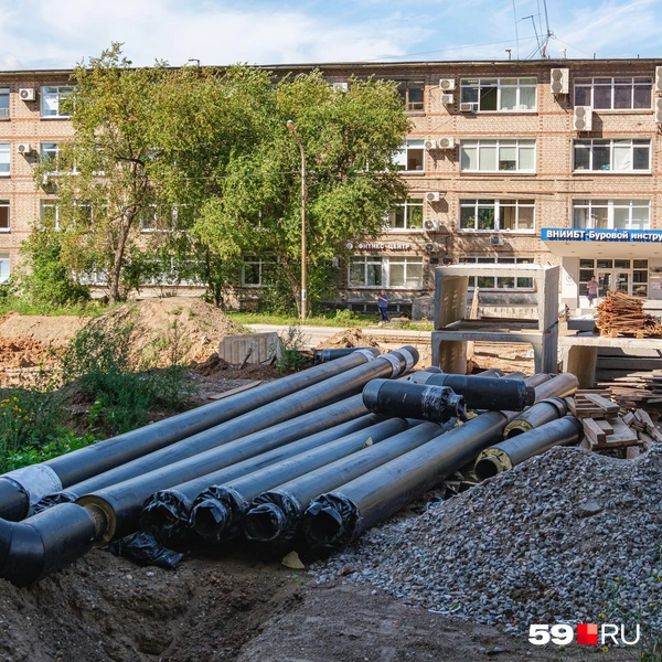 Позади труб лежат бетонные блоки, в которые их и укладывают под землёй | Источник: Тимофей Калмаков / 59.RU
