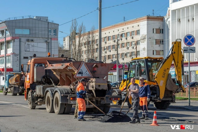 Над размещением дорожных заплаток трудится бригада рабочих и четыре машины | Источник: Константин Завриков / V1.RU