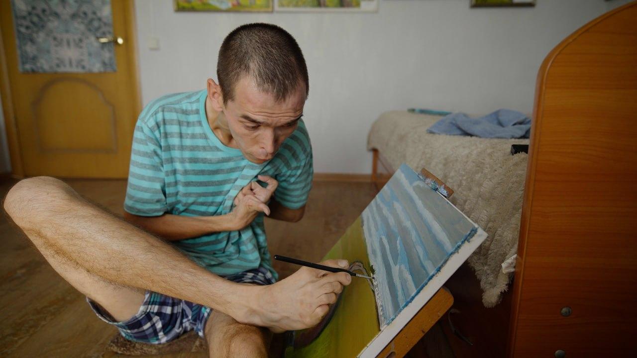 «Врачи говорили: будет неполноценный, лежачий». Художник с ДЦП научился писать уникальные картины — они разлетаются по частным коллекциям