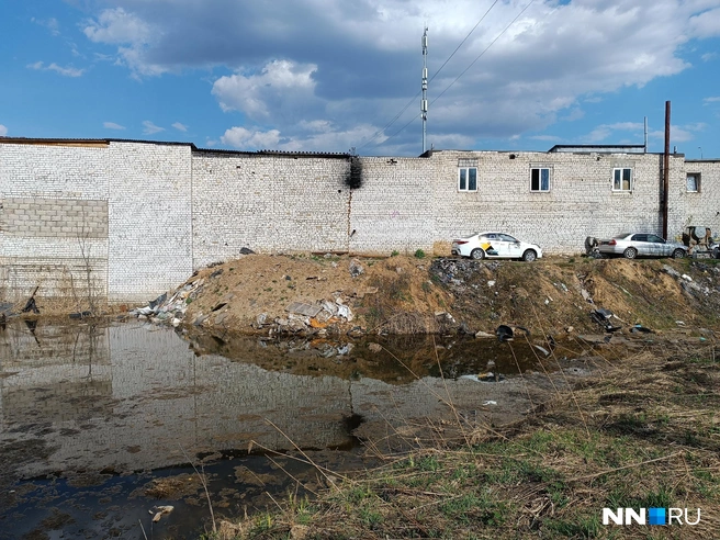 Кладбище окружено грязным водоемом и гаражами | Источник: Кристина Калинина / NN.RU