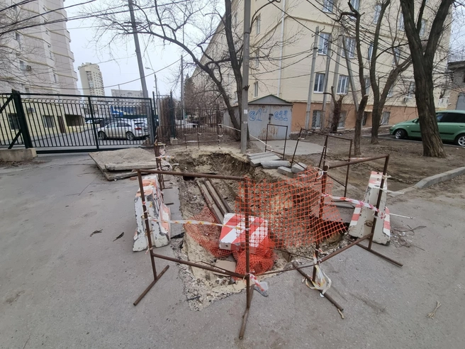 На дне ямы виднеются ржавые трубы и бетонный блок. | Источник: Константин Завриков / V1.RU