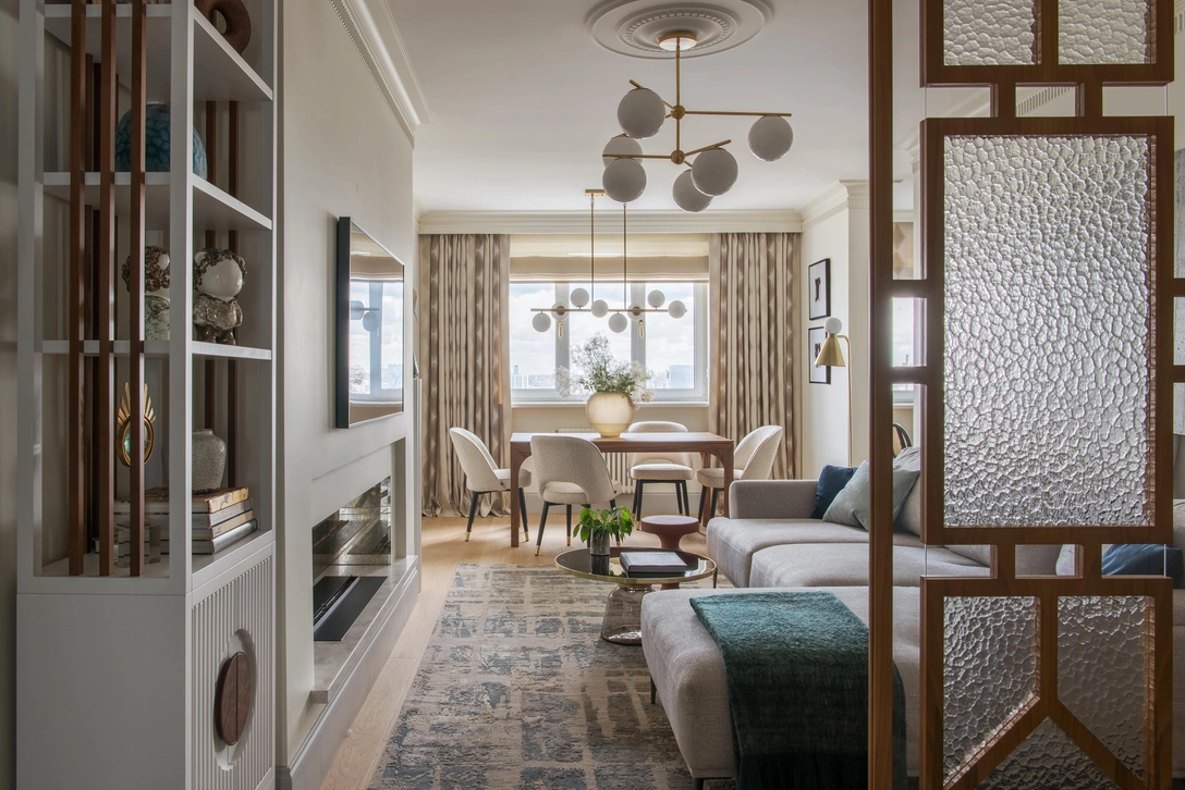 Гостиная. Диван, Dantone Home. Обеденный стол сделан по чертежам дизайнера в столярной мастерской «КорниловЪ». Стулья, Eichholtz. Столик, Moon Stores. Стеллаж, перегородка, постамент изготовлены по чертежам дизайнера в столярной мастерской Григория Титова. Светильники West Elm, Light Star. Текстиль, Filimonova Textile. Ковер, Design carpets. | Источник: Ольга Мелекесцева. Стиль: Юлия Чеботарь