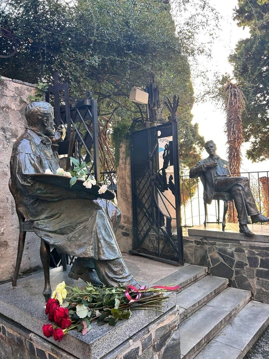 У входа в музей сидят двое: художник Коровин пишет портрет оперного певца Шаляпина | Источник: Музей Константина Коровина в Гурзуфе / Telegram