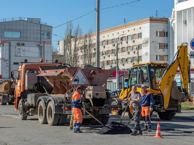 Бригада рабочих и несколько единиц техники заняты ремонтом дорожного покрытия. | Источник: Константин Завриков / V1.RU