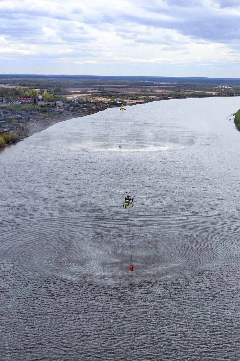 Вертолет с помощью специального водозаборного устройства собирает воду для тушения  | Источник: предоставлено Сергеем 