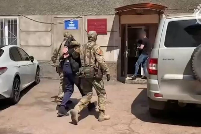 Силовики ведут одного из задержанных | Источник: ГСУ СК России по Красноярскому краю и республике Хакасия / telegram