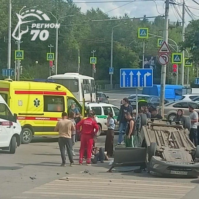 Hyundai лежит на крыше, а рядом с ним человек  | Источник: телеграм-канал «Регион-70»