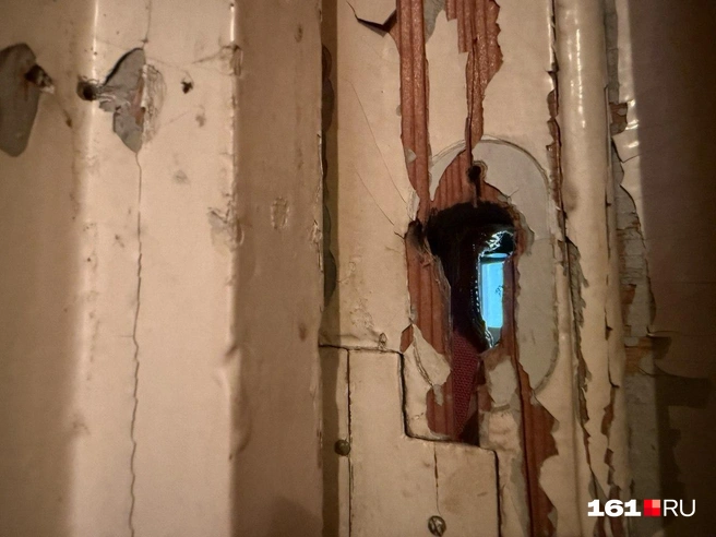 Замок из двери давно выломали, теперь сквозь отверстие можно увидеть коридор и санузел. Чтобы открыть дверь снаружи, надо пальцем уцепиться за эту дырку | Источник: Марина Рыбалкина / 161.RU