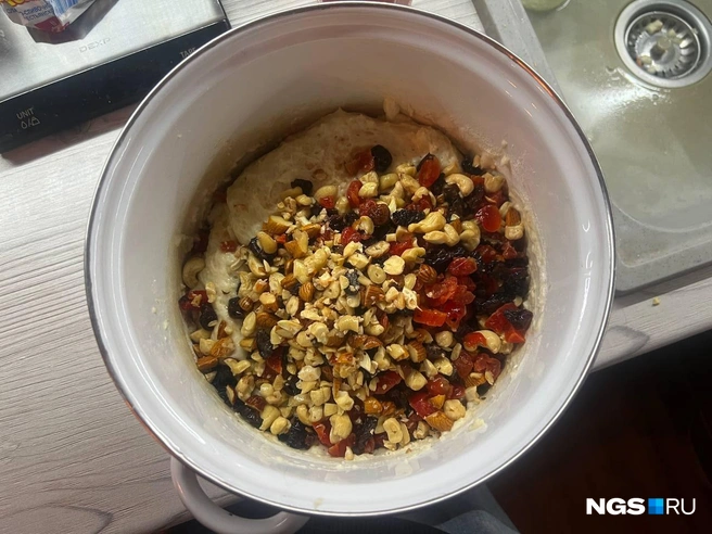 В готовое тесто вмешайте орехи и сухофрукты, жидкость от них сливать не надо — она еще пригодится. | Источник: Анна Скок / NGS.ru