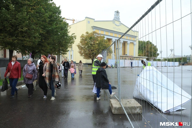 На железные заборы у одного из павильонов вешают баннеры  | Источник: Дмитрий Толстошеев / MSK1.RU