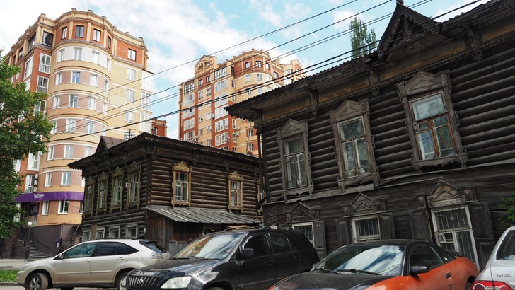Старинные бревенчатые дома Томска на фоне новых многоэтажных домов. | Источник: Чиженок Александр/PhotoXPress.ru