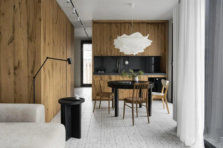 Кухню и прихожую отделяет откатная дверь, которая в закрытом виде сливается с деревянными фасадами шкафов, где спрятано инженерное оборудование и холодильник. Проект бюро MEL | Источник: Ольга Мелекесцева