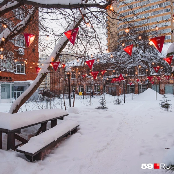 Скамьи и столик во дворе замело, но стоит посмотреть наверх, чтобы заметить красоту | Источник: Тимофей Калмаков / 59.RU