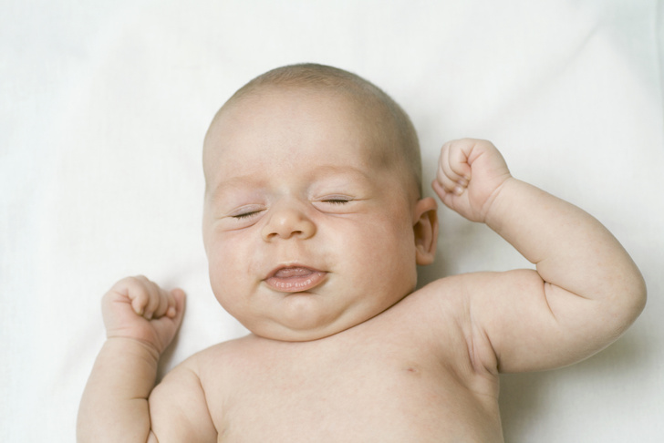 Новорожденный сжимает кулачки, пушковые волосы у ребенка