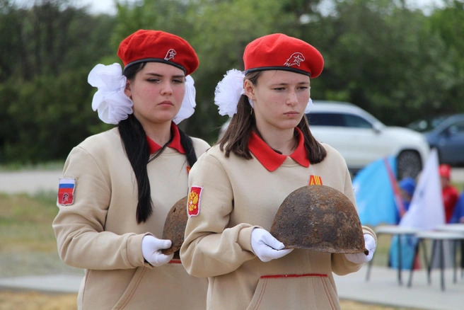 Юнармейцы возлагают на свежую могилу найденные поисковиками пробитые советские каски | Источник: пресс-служба УФСБ по Волгоградской области