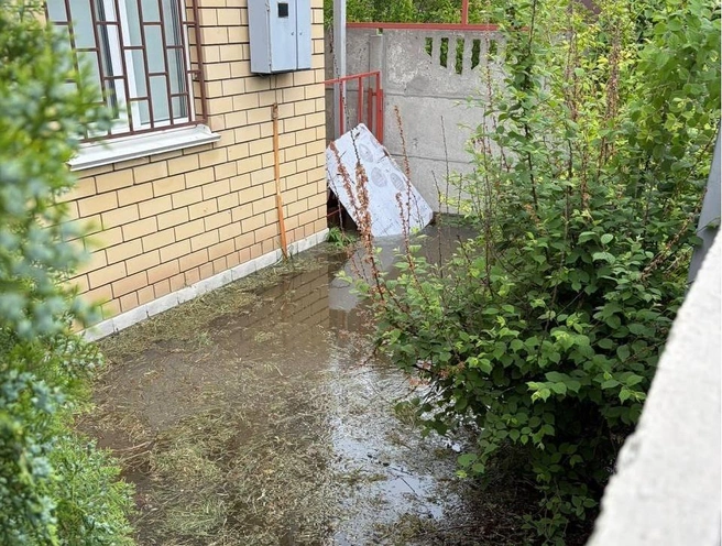 Вода во дворе, по словам жителей тонущего дома, поднялась уже до колен | Источник: читатели V1.RU