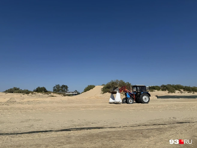 Трактор убирает с пляжа мешки, в которые спасатели складывают замазученный песок | Источник: Валерия Дульская / 93.RU