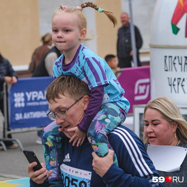 Футболка у девочки показывает, что она уже пробежала свою дистанцию. Теперь, семья, видимо, болеет за второго ребенка или кого-то из знакомых | Источник: Тимофей Калмаков / 59.RU