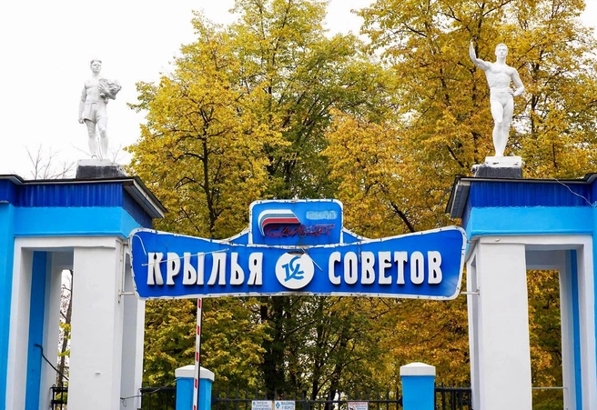 Первое, что видит посетитель,&nbsp;— красивая арка с фигурами двух мускулистых мужчин на крыше. Над воротами висит табличка с названием стадиона и эмблемой футбольного клуба «Крылья Советов», чьи игроки когда-то бегали по местному полю | Источник: Фёдор Тенин / Дзен 