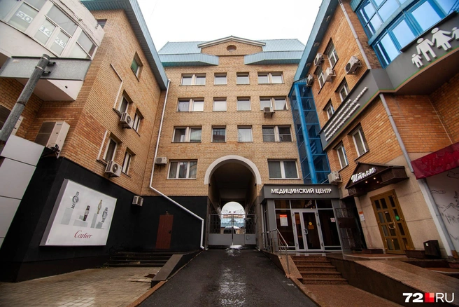 Дом действительно чем-то напоминает крепость. Въезд через арку с массивными воротами, песочного цвета стены из кирпича | Источник: Ирина Шарова / 72.RU