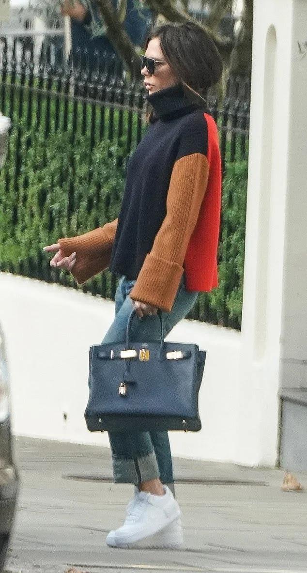 Редкое фото: Виктория Бекхэм в свитере в стиле color block и кедах гуляет по Лондону