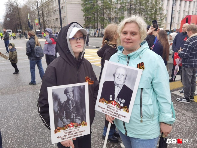 Валентина и Михаил держат в руках портреты родных, прошедших войну | Источник: Тимофей Калмаков / 59.RU