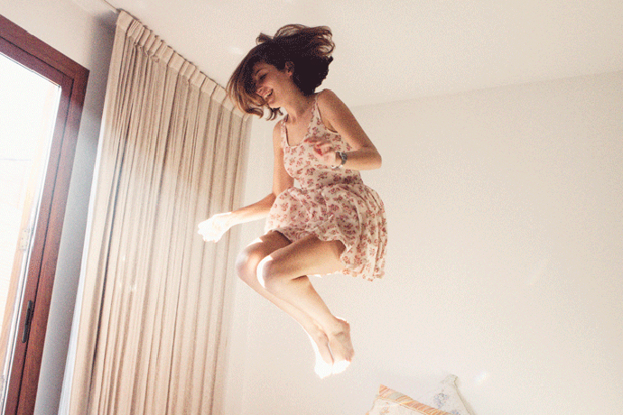 Девушка, прыгающая на кровати