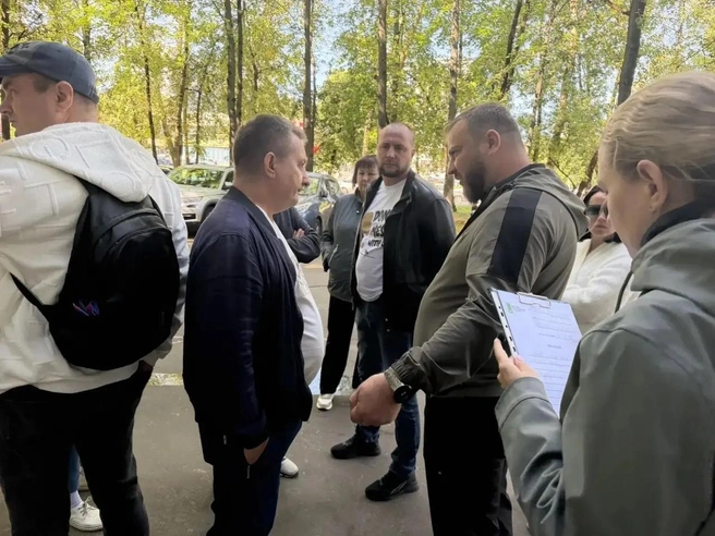 Игорь Головко — в центре, в белой футболке Don't mess with me. Смотрит за общением первого замглавы управы Зенина (справа) с жителем района | Источник: «Управа района Чертаново Центральное» / Vk.ru